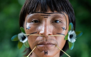 Ehuana Yaira Yanomami, artista y activista del pueblo Yanomami, con elementos visuales que reflejan la seva conexión con la cultura y la lluita pels drets indígenes